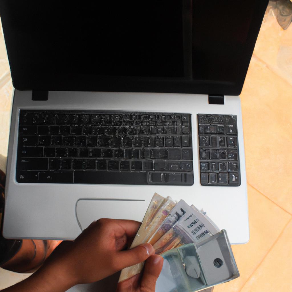Person holding money and laptop
