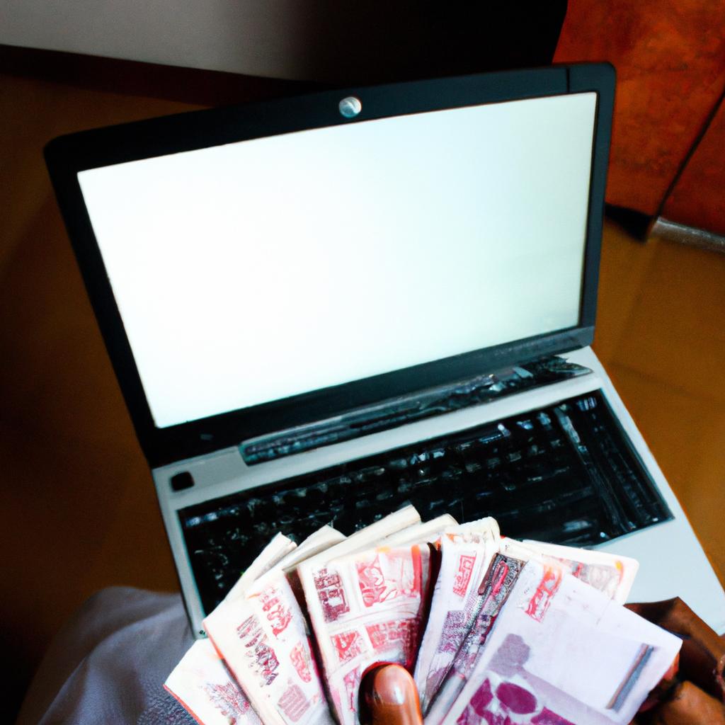 Person holding money and laptop